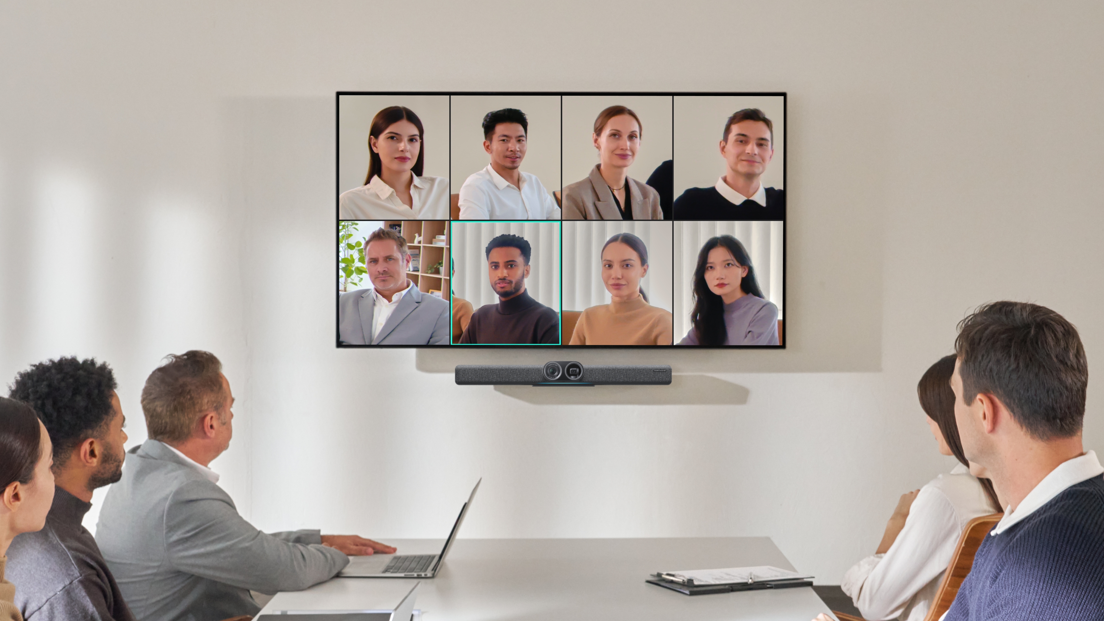 A large meeting room with Insta360 Connect linked up to a big TV, showing all of the people in the meeting on the screen.